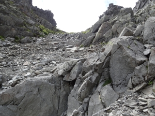 左岸の岩をホールドにガレを登る